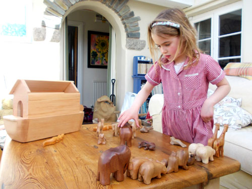 Girl playing with handcrafted, Wooden Noah's Arks